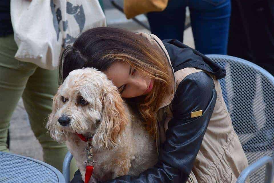 A Young lady hugging her emotional support animal or ESA Dog